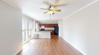 Located at 5232 N Sheridan Road in Chicago's vibrant Edgewater neighborhood, this single-floor unit offers a thoughtfully designed layout with warm hardwood flooring throughout. The open-concept living area is bright and airy, benefiting from large windows that invite abundant natural light and a ceiling fan that adds both function and comfort. Crown molding provides a refined finish to the living space.

The kitchen is centrally positioned and features rich cherry wood cabinetry, granite-style countertops, a gas range, a black refrigerator, and a double sink. A peninsula counter separates the kitchen from the living area, creating a practical and social layout. Multiple windows in the kitchen area allow for additional natural light and views of the surrounding neighborhood.

The bedroom is generously proportioned, with hardwood floors, a ceiling fan, and natural light from a side window. Charming barn-style sliding doors open to a walk-in closet with built-in shelving and hanging space, offering ample storage. A secondary closet area with additional shelving provides further organizational options.

The bathroom is clean and functional, featuring white tile work, a tub-shower combination with a handheld showerhead, a single vanity with an integrated sink, and a mirrored medicine cabinet. A window provides natural ventilation. Classic cast-iron radiators are present throughout, characteristic of Chicago's architectural heritage.