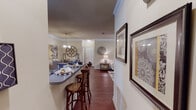 This single-story residence offers a thoughtfully designed layout that balances comfort and functionality across its main living spaces. Rich hardwood-style flooring flows through the primary areas, complemented by crown molding and textured ceilings that add architectural character throughout.

The living room is a welcoming, generously sized space featuring a tray ceiling, ceiling fan, and access to an exterior door that brings in natural light. It connects seamlessly to a dedicated dining area, which is accented by a pendant light fixture and offers ample room for entertaining.

The galley-style kitchen is well-equipped with stainless steel appliances, including a refrigerator, range, and built-in microwave, alongside warm wood cabinetry, dark granite-style countertops, and a double sink. A breakfast bar provides additional seating and opens toward the dining area.

Two bedrooms offer comfortable retreats, each with plush carpet, ceiling fans, and multiple windows dressed with blinds and curtains. The primary bedroom is notably spacious, while both bathrooms feature wood-style flooring, vanities with dark countertops, and tub-shower combinations with tile surrounds. An in-unit laundry area adds everyday convenience.