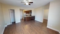 This single-floor residence offers a thoughtfully designed layout that combines comfort and functionality. The open-concept living area flows seamlessly into the kitchen, unified by rich wood-look tile flooring that runs throughout the space. Ceiling fans are present in the main living areas and bedrooms, contributing to a comfortable atmosphere year-round.

The kitchen is a standout feature, equipped with dark espresso cabinetry, light granite-style countertops, stainless steel appliances including a refrigerator, gas range, and microwave, and a decorative mosaic tile backsplash that adds visual interest. A peninsula with additional cabinet storage and counter seating connects the kitchen to the living area, making it ideal for casual dining or entertaining.

The bedrooms are generously sized, each featuring wood-look tile flooring, ceiling fans, and windows with blinds that allow for natural light. One bedroom includes a cast iron radiator, adding a classic architectural detail.

The bathroom is elegantly finished with large-format beige wall tiles, a mosaic accent border, a walk-in shower with a brushed nickel fixture, and a white vanity. The textured ceilings throughout add a layer of traditional character to the overall design of this well-maintained space.