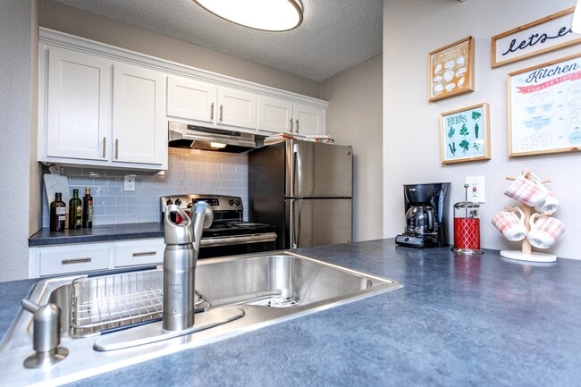Cocina moderna con electrodomésticos de acero inoxidable en Domain Apartments en Norcross, GA - Domain Apartments