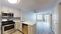 Located at 441 W Third St in San Pedro, Los Angeles, this single-floor unit offers a clean, modern design with a cohesive neutral color palette throughout. The open-concept layout seamlessly connects the kitchen and living area, creating a bright and functional living space. Light wood-style flooring runs throughout, complementing the warm beige tones of the walls.

The kitchen is well-appointed with crisp white shaker cabinets, a mosaic tile backsplash, and a full suite of stainless steel appliances including a gas range, microwave, refrigerator, and dishwasher. A peninsula with a white quartz countertop provides additional prep space and serves as a natural divider between the kitchen and living area.

The spacious living area benefits from abundant natural light through large windows with blinds and a sliding glass door leading to an outdoor balcony or patio. A ceiling fan adds comfort to the room.

A dedicated hallway connects to the bedroom and bathroom. The bedroom features dual windows, a ceiling fan, and generous floor space. The bathroom is finished with a quartz vanity countertop, an integrated sink, and a large wall mirror. Throughout the unit, textured ceilings and clean white trim add to the polished, move-in-ready feel of the space.