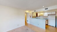 Located at 1993 Water Street in Morgantown, WV, this single-floor unit offers four bedrooms and three bathrooms within a well-organized layout. The combined kitchen and living area serves as the heart of the home, where the kitchen features white cabinetry with warm wood trim accents, blue laminate countertops, a peninsula breakfast bar, and white appliances including a range and refrigerator. Recessed lighting and hardwood-style flooring give the kitchen a clean, functional character. The adjoining living room transitions to soft carpeting, creating a comfortable, defined space for relaxing. Two hallways connect the various rooms, ensuring smooth circulation throughout. The four bedrooms are carpeted and finished in neutral tones, providing a calm and versatile environment. The primary bedroom stands out with a sliding glass door that opens to a private balcony, offering outdoor access and natural light. The three bathrooms are compactly designed with white vanities, wood-trimmed cabinetry, and well-lit mirrors. A textured ceiling is featured throughout much of the unit. The overall layout is efficient and practical, making this a well-suited space for shared or family living in the heart of Morgantown.
