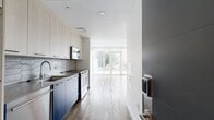 Located at 11300 Fairmount Ave in Philadelphia, PA, this 560-square-foot, one-bedroom, one-bathroom unit delivers a clean, modern aesthetic with high-quality finishes. The open-concept layout connects the kitchen and living area seamlessly, with warm hardwood flooring extending throughout. The kitchen is a standout feature, showcasing bold navy lower cabinets paired with light wood upper cabinetry, a geometric hexagonal tile backsplash, stainless steel appliances including a built-in dishwasher, electric range, and microwave, along with sleek countertops and a single-basin sink. Floor-to-ceiling sliding glass doors in the living area flood the space with natural light and provide direct views of the surrounding greenery. The 150-square-foot bedroom offers a bright, clean environment with white walls and hardwood floors. The bathroom is elegantly tiled with large hexagonal wall tiles in the tub/shower surround, warm terracotta-toned floor tiles, a wood-accented vanity, and a sliding glass shower enclosure. A dedicated closet adds practical storage. The unit's contemporary design, abundant natural light, and quality materials make it a refined urban living space.