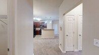 Located at 405 Grand Wailea Dr in Fayetteville, NC, this single-floor, 2-bedroom, 2-bathroom home offers a well-designed layout that maximizes functionality and comfort. The open-concept living, dining, and kitchen area serves as the heart of the home, with the kitchen featuring rich dark wood cabinetry, granite-style countertops, a peninsula breakfast bar, pendant lighting, and black appliances including a refrigerator, range, and built-in microwave. Wood-look flooring anchors the kitchen, while plush carpet extends throughout the living areas and bedrooms. The spacious living room is bathed in natural light through French doors and a ceiling fan overhead. Both bedrooms are generously sized, each featuring carpet flooring, ceiling fans, and large windows that bring in abundant natural light. The primary bedroom includes access to a roomy walk-in closet outfitted with wire shelving. A second bedroom also features its own closet. The bathrooms are clean and functional, with one featuring a full soaking tub and shower combination with brushed nickel fixtures. Additional highlights include a dedicated laundry room with washer and dryer hookups, a pantry, a utility room, and an impressive six closets throughout, ensuring ample storage at every turn.