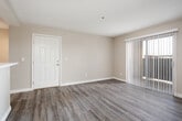 Located at 18194 McCauley St in Fontana, California, this single-story unit offers a well-designed, open-concept layout that seamlessly connects the living, dining, and kitchen areas. The living space is finished with durable wood-style flooring throughout and features a ceiling fan, along with a sliding glass door fitted with vertical blinds that fills the room with natural light and provides access to the outdoors.

The kitchen is a standout feature, equipped with rich dark espresso cabinetry, light quartz countertops, a stainless steel range, microwave, dishwasher, and a deep single-basin sink. Recessed lighting overhead enhances the modern aesthetic, and the open peninsula integrates the kitchen naturally into the main living area.

The bedrooms are carpeted with neutral-toned walls and feature sliding panel closets or reach-in closets, providing ample storage. Windows with horizontal blinds allow for natural light while maintaining privacy.

The bathrooms are finished with matching dark wood vanities topped with quartz countertops, tile-style flooring, and full tub-shower combinations. Brushed nickel fixtures and well-lit vanity mirrors complete the clean, contemporary look. The overall ambiance of the unit is light, neutral, and move-in ready, offering a functional and comfortable living environment.