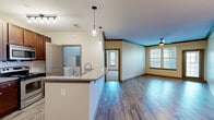 This well-appointed 2-bedroom, 2-bathroom single-story residence at 5400 Chenonceau Blvd in Little Rock, AR offers a thoughtfully designed layout across a comfortable footprint. The open-concept living and kitchen area is anchored by durable hardwood-style flooring, crown molding, and a ceiling fan, creating a bright and welcoming atmosphere. Large windows fitted with blinds allow natural light to fill the space throughout.

The kitchen features rich dark wood cabinetry, granite countertops, a peninsula with pendant lighting and a built-in sink, stainless steel appliances including a refrigerator and electric range, and a dishwasher — ideal for both everyday cooking and entertaining.

Both bedrooms are generously sized, finished with plush carpeting, ceiling fans, and multiple windows that bring in natural light. The primary bedroom offers a spacious layout with its own closet. Each bathroom is equipped with granite vanity countertops, dark wood cabinetry, and a tub/shower combination, with a window providing ventilation and natural light.

A dedicated laundry room houses a full-sized washer and dryer and includes built-in shelving for added storage. Two closets and a hallway round out the functional layout, making this a practical and comfortable home in Little Rock.