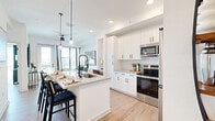 Located at 1701 N Florida Ave in Tampa, FL, this thoughtfully designed one-bedroom, one-bathroom residence offers a well-appointed single-floor layout with modern finishes throughout. The open-concept kitchen and living area serves as the heart of the home, anchored by a large quartz-topped island with an undermount sink, matte black fixtures, and pendant lighting. White shaker cabinetry reaches toward the ceiling, complemented by a full suite of stainless steel appliances including a range, microwave, and refrigerator. Light wood-tone flooring flows seamlessly throughout the space, enhancing the bright and airy atmosphere created by recessed lighting and large windows. The living area connects naturally to the kitchen, offering a functional and inviting layout. The bedroom is a serene retreat featuring floor-to-ceiling windows with city views, generous natural light, and access to a well-sized walk-in closet. The bathroom is finished with a soaking tub-shower combination adorned with tiled surround, a white vanity with stone countertops, and matte black hardware accents. Additional conveniences include a dedicated laundry area, an entrance foyer, and two closets for ample storage. The clean, contemporary aesthetic is consistent throughout, making this residence a refined urban home.