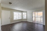 Located along Rancho California Road in Temecula, CA, this single-story residence offers a well-organized and functional layout throughout. The living area is finished with durable wood-style flooring and features a sliding glass door that opens to a private balcony, allowing natural light to fill the space and providing views of the surrounding neighborhood. A textured ceiling is consistent throughout the main living spaces, adding a classic residential character.

The kitchen is efficiently designed with white cabinetry offering ample upper and lower storage, light-toned countertops, and a pass-through window connecting to the main living area. It is equipped with a gas range, over-the-range microwave, stainless steel dishwasher, and a double-basin sink beneath a window that brings in additional natural light.

The bedrooms are carpeted for comfort, with neutral-toned walls and textured ceilings. The primary bedroom includes a sliding glass door to the balcony and access to a dedicated closet with built-in shelving. A ceiling fan adds to the room's utility. Additional built-in cabinetry with upper and lower cabinets and a countertop workspace provides practical storage options. The bathroom includes a tiled shower-tub combo, wood-style flooring, and clean, neutral finishes throughout.