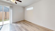 Located at 16336 Cameron Road in Pflugerville, TX, this two-story home offers three bedrooms and three bathrooms across a well-designed layout. The main floor provides a generous open-concept living area with light wood-look flooring, recessed lighting, and a ceiling fan, flowing seamlessly into the kitchen. The kitchen is outfitted with white shaker-style cabinetry, granite countertops, stainless steel appliances including a range, over-the-range microwave, and dishwasher, plus a undermount sink positioned beneath a window for natural light. A carpeted staircase with a clean white railing leads to the upper level. The primary bedroom features hardwood-style flooring, dual windows, a ceiling fan, and a walk-in closet complete with built-in shelving and hanging rods. Additional bedrooms include ceiling fans and closet storage, with one featuring plush carpet. The bathrooms are finished with granite vanities, wood-look flooring, and tiled tub-surround combinations. Outside, a private backyard is enclosed by a modern horizontal wood-slat fence with black steel posts, a patio slab, and a gated entry — ideal for outdoor relaxation.