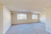 Located at 539 Thayer Ave in Silver Spring, Maryland, this one-bedroom, one-bathroom residence offers a thoughtfully organized single-floor layout. The combined living and dining area is the heart of the home, featuring wall-to-wall carpet, neutral cream-toned walls, and two generous windows that usher in natural light and views of the surrounding neighborhood. A ceiling fan adds both function and comfort to this open, airy space.

The kitchen is equipped with rich, dark-stained wood cabinetry, light granite-style countertops, a gas range, and a full-size refrigerator, all set atop wood-look flooring that extends through the entry hallway. The entryway provides a clear transition point between the hard-surface and carpeted areas of the home.

The bedroom is a comfortable, well-proportioned retreat, complete with soft carpeting, a ceiling fan with light fixture, a window with blinds for natural light, and a closet offering practical built-in storage. An additional closet elsewhere in the unit provides further organizational flexibility.

The bathroom is bright and clean, featuring a white vanity with storage, a shower/tub combination, a wall mirror, and a small window. Wood-look flooring ties the space together with a fresh, updated feel. The overall ambiance of this residence is clean, neutral, and move-in ready.