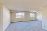 Located at 539 Thayer Ave in Silver Spring, Maryland, this one-bedroom, one-bathroom residence offers a thoughtfully organized single-floor layout. The combined living and dining area is the heart of the home, featuring wall-to-wall carpet, neutral cream-toned walls, and two generous windows that usher in natural light and views of the surrounding neighborhood. A ceiling fan adds both function and comfort to this open, airy space.

The kitchen is equipped with rich, dark-stained wood cabinetry, light granite-style countertops, a gas range, and a full-size refrigerator, all set atop wood-look flooring that extends through the entry hallway. The entryway provides a clear transition point between the hard-surface and carpeted areas of the home.

The bedroom is a comfortable, well-proportioned retreat, complete with soft carpeting, a ceiling fan with light fixture, a window with blinds for natural light, and a closet offering practical built-in storage. An additional closet elsewhere in the unit provides further organizational flexibility.

The bathroom is bright and clean, featuring a white vanity with storage, a shower/tub combination, a wall mirror, and a small window. Wood-look flooring ties the space together with a fresh, updated feel. The overall ambiance of this residence is clean, neutral, and move-in ready.