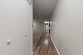 Located at 23445 S Western Ave in Park Forest, IL, this single-floor, one-bedroom, one-bathroom residence offers a well-organized layout across a comfortable footprint. The unit is connected by a long hallway finished with warm hardwood-style flooring that runs throughout the common areas, creating a cohesive and clean aesthetic.

The kitchen is a standout feature, equipped with rich dark-wood cabinetry, light countertops, and stainless steel appliances including a refrigerator and dishwasher. An adjacent pantry with built-in shelving provides generous storage space, adding notable practicality to the kitchen area.

The spacious bedroom is carpeted and benefits from natural light through a window with blinds. A wall-unit air conditioner and baseboard heating ensure year-round comfort. The room includes a full-width built-in closet with bifold doors, offering ample storage.

The living area is distinguished by a striking exposed brick accent wall and vertical blinds covering a large window, lending the space a warm, character-filled atmosphere. The full bathroom features wood-look flooring, a soaking tub, and floor-to-ceiling dark tile surround, providing a clean, modern finish. Overall, the unit presents a functional and inviting living space.