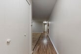 Located at 23445 S Western Ave in Park Forest, IL, this single-floor, one-bedroom, one-bathroom residence offers a well-organized layout across a comfortable footprint. The unit is connected by a long hallway finished with warm hardwood-style flooring that runs throughout the common areas, creating a cohesive and clean aesthetic.

The kitchen is a standout feature, equipped with rich dark-wood cabinetry, light countertops, and stainless steel appliances including a refrigerator and dishwasher. An adjacent pantry with built-in shelving provides generous storage space, adding notable practicality to the kitchen area.

The spacious bedroom is carpeted and benefits from natural light through a window with blinds. A wall-unit air conditioner and baseboard heating ensure year-round comfort. The room includes a full-width built-in closet with bifold doors, offering ample storage.

The living area is distinguished by a striking exposed brick accent wall and vertical blinds covering a large window, lending the space a warm, character-filled atmosphere. The full bathroom features wood-look flooring, a soaking tub, and floor-to-ceiling dark tile surround, providing a clean, modern finish. Overall, the unit presents a functional and inviting living space.