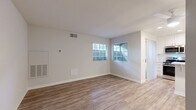 Located at 1480 S Highland Ave in Fullerton, CA, this efficiently designed one-bedroom, two-bathroom residence offers a clean, modern aesthetic throughout its single floor. Wood-look plank flooring flows seamlessly across the open living and dining area, which is brightened by multiple windows with slatted blinds that allow natural light to fill the space. The combined living and dining room provides a comfortable, open layout well-suited for everyday living.

The kitchen is thoughtfully appointed with crisp white shaker-style cabinetry, light quartz countertops, recessed lighting, and a peninsula with bar seating that doubles as a casual dining surface. Stainless steel appliances, including a gas range, microwave, and sink with a pull-down faucet, complete the functional cooking space. A sliding glass door off the kitchen leads to a private patio with textured stucco walls and an overhead light fixture, offering a compact outdoor retreat.

The bedroom is a well-proportioned private retreat, and two closets provide ample storage. Both bathrooms are finished in clean white tones, featuring white vanity cabinetry and a tub-shower combination. Mirrored closet doors enhance the sense of space in the bathroom hallway. The overall ambiance is bright, neutral, and move-in ready.