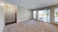 Located at 1801 E Girard Place in Englewood, Colorado, this two-bedroom, one-bathroom unit offers a comfortable and functional single-floor layout. The open living room is bathed in natural light from multiple windows and a sliding glass door that leads to a private balcony, offering pleasant outdoor views of surrounding greenery. Soft, neutral-toned carpet throughout the living and bedroom areas creates a warm and cohesive feel.

The kitchen is thoughtfully appointed with light wood cabinetry, granite-style countertops, a white subway tile backsplash, wood-look vinyl flooring, and a full suite of stainless steel appliances including a range, microwave, and refrigerator. A breakfast bar adds additional counter space and versatility.

The primary bedroom is generously sized, featuring a large window for natural light and two closets for ample storage. The second bedroom also includes a window and closet, both rooms finished with the same plush carpeting found throughout the unit.

The bathroom is well-finished with wood-look vinyl flooring, a light wood vanity topped with granite-style counters, a large wall mirror, and a full soaking tub with floor-to-ceiling tile surround. A hallway connects the main living areas, completing the efficient and practical layout of this Englewood residence.