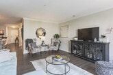 This single-floor residence at 553 Settlers Landing in Hampton, Virginia offers a thoughtfully designed layout that balances comfort and functionality. The open-concept living area features rich hardwood-style flooring, crown molding, and large windows that allow generous natural light to fill the space. A sliding glass door in the living room provides access to outdoor views and enhances the sense of openness. The living and dining areas flow seamlessly together, creating an ideal space for both relaxing and entertaining.

The kitchen is equipped with warm honey-toned cabinetry, dark granite-style countertops, and stainless steel appliances, including a range and microwave. The hardwood-style flooring continues throughout, maintaining a cohesive aesthetic.

The primary bedroom is generously sized with plush carpeting, multiple windows with outdoor views, and ample room for substantial furnishings. A secondary bedroom offers similar comfort with carpet flooring and bright windows. Both bathrooms feature tub-shower combinations with tile surrounds, wood-tone vanity cabinetry, and hardwood-style flooring, presenting a clean and contemporary feel. Throughout the residence, neutral wall tones and consistent finishes create a warm, welcoming ambiance.