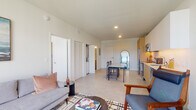 Located at 280 NW 29th St in Miami's vibrant Wynwood neighborhood, this single-floor unit offers a well-designed, open-concept interior with a clean, modern aesthetic throughout. Large floor-to-ceiling windows in both the living area and bedroom flood the space with natural light while framing elevated views of the surrounding cityscape.

The open living and dining area flows seamlessly into the kitchen, which features a combination of white upper cabinetry and warm wood lower cabinets, stainless steel appliances including a refrigerator, range, microwave, and dishwasher, and a marble-top dining table that doubles as a central gathering point. Light-toned large-format tile flooring runs throughout, contributing to a cohesive and airy feel.

The bedroom is generously proportioned, benefiting from expansive windows that offer city views and ample natural light. It is complemented by closet storage and a calm, neutral palette. The bathroom is finished with large-format gray stone-look tile on both the floor and walls, and includes a spacious glass-enclosed walk-in shower and a wood-accented vanity, delivering a refined, spa-like atmosphere.