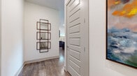 Located at Watercourse Drive in Fort Worth, TX, this thoughtfully designed two-bedroom, two-bathroom residence offers a comfortable and modern living experience across a single floor. Rich wood-style flooring flows consistently throughout, lending warmth and cohesion to every room.

The open kitchen is a standout feature, showcasing dark two-tone cabinetry extending to the ceiling for ample storage, crisp white countertops, a soft blue-green subway tile backsplash, and a full suite of stainless steel appliances. The adjacent living room is bright and inviting, with large sliding glass doors that open to a private balcony overlooking lush greenery — a seamless connection between indoor and outdoor living. A horizontal clerestory window adds an additional layer of natural light.

The spacious primary bedroom offers generous proportions, large windows with garden views, and direct access to an en suite bathroom featuring dark cabinetry, white countertops, a walk-in glass-enclosed shower with marble-style tile, and a well-organized walk-in closet. The second bedroom is equally bright, with tall windows framing outdoor views and its own access to a full bathroom with a dark-vanity and an adjacent walk-in closet. Clean white walls and panel-style interior doors complete the refined, contemporary aesthetic throughout.