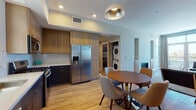 Located on Glencoe Avenue in the heart of Marina del Rey, Los Angeles, this single-floor residence offers a thoughtfully designed layout with modern finishes throughout. Light hardwood flooring connects each area of the home, creating a cohesive and welcoming atmosphere.

The kitchen is a standout feature, equipped with stainless steel appliances including a gas range, built-in microwave, dishwasher, and a full-size side-by-side refrigerator. Two-tone cabinetry pairs warm wood uppers with dark lower cabinets, complemented by a white quartz countertop and subtle tile backsplash. The kitchen flows directly into the dining area, where a circular wood dining table beneath a statement pendant light creates an inviting space for meals.

The living room benefits from floor-to-ceiling windows and a glass door that open to sweeping views of the surrounding Marina del Rey skyline, filling the space with abundant natural light. The bedroom is a calm retreat with hardwood floors, large windows, and ample natural light. The bathroom features a full soaking tub and shower combination with neutral tile surround and tile flooring. An in-unit stacked washer and dryer adds everyday convenience to this well-appointed home.