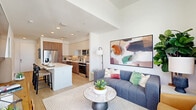 Located at 7800 E Peakview Ave in Centennial, Colorado, this thoughtfully designed one-bedroom, one-bathroom residence offers a modern open-concept layout with stylish finishes throughout. Light-toned hardwood flooring flows seamlessly across the main living areas, complementing the bright, white walls and recessed lighting overhead.

The kitchen is a standout feature, showcasing a two-tone design with warm wood lower cabinetry, crisp white upper cabinets, and a geometric tile backsplash. Stainless steel appliances, including a French-door refrigerator, dishwasher, microwave, and range, provide a fully equipped cooking space. A generous white waterfall island with bar seating makes for effortless entertaining.

The open living room is bathed in natural light from floor-to-ceiling windows that frame sweeping panoramic views of the surrounding Centennial skyline and mountains beyond. A private balcony extends the living space outdoors.

The bedroom offers a serene retreat with plush carpeting, a ceiling fan, and large windows that continue the expansive views. Two closets provide ample storage. The bathroom features warm wood vanity cabinetry with gold hardware, a white countertop, and a tiled walk-in shower. A built-in entryway nook with shelving and hooks adds a functional and charming touch near the entrance.