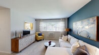 This well-appointed 2-bedroom, 1-bathroom residence is thoughtfully laid out across a single floor, making efficient use of its space. The living room serves as the heart of the home, featuring plush carpet, a large window with outdoor views, and a striking teal accent wall that adds bold character to the otherwise neutral palette. The open sightline to the kitchen enhances the sense of space throughout the common area.

The kitchen is outfitted with white shaker cabinetry, light granite countertops, and stainless steel appliances including a gas range and over-the-range microwave, providing a clean, functional cooking space.

The primary bedroom offers a comfortable footprint with carpet flooring, a window for natural light, and ample closet storage. The second bedroom also features a teal accent wall, carpet flooring, and a window, making it a versatile space. Both bedrooms are connected via hallways that contribute to an organized flow throughout the unit.

The bathroom includes a full tub-shower combination, a single vanity with brushed nickel fixtures, and a mirror, maintaining a clean and functional aesthetic. Overall, the residence balances practical design with thoughtful stylistic touches.