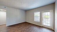 Located at 3232 N Locust St in Denton, TX, this one-bedroom, one-bathroom residence offers a well-organized single-floor layout designed for efficient, comfortable living. The open living and dining area is finished with rich, dark hardwood-style flooring and neutral-toned walls, creating a clean and versatile backdrop. Natural light filters in through blinded windows, and a glass-panel entry door adds brightness to the main living space.

The kitchen is a standout feature, equipped with a full suite of stainless steel appliances — including a refrigerator, range, microwave, and dishwasher — complemented by gray shaker-style cabinetry and light countertops. The layout maximizes functionality within the available space.

The bedroom is carpeted for comfort, features a ceiling fan, a window with natural light, and connects to two closets, providing ample storage. The bathroom includes a full tub-shower combination with white tile surround, wood-style flooring, and built-in cabinetry for additional storage.

A dedicated in-unit laundry area houses a full-size top-load washer with wire shelving overhead, adding everyday convenience. Throughout the residence, clean white trim, neutral walls, and consistent flooring tie the space together cohesively.
