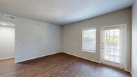 Located at 3232 N Locust St in Denton, TX, this one-bedroom, one-bathroom residence offers a well-organized single-floor layout designed for efficient, comfortable living. The open living and dining area is finished with rich, dark hardwood-style flooring and neutral-toned walls, creating a clean and versatile backdrop. Natural light filters in through blinded windows, and a glass-panel entry door adds brightness to the main living space.

The kitchen is a standout feature, equipped with a full suite of stainless steel appliances — including a refrigerator, range, microwave, and dishwasher — complemented by gray shaker-style cabinetry and light countertops. The layout maximizes functionality within the available space.

The bedroom is carpeted for comfort, features a ceiling fan, a window with natural light, and connects to two closets, providing ample storage. The bathroom includes a full tub-shower combination with white tile surround, wood-style flooring, and built-in cabinetry for additional storage.

A dedicated in-unit laundry area houses a full-size top-load washer with wire shelving overhead, adding everyday convenience. Throughout the residence, clean white trim, neutral walls, and consistent flooring tie the space together cohesively.