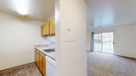 Located at 5711 Castlebridge Rd in Fredericksburg, Virginia, this two-bedroom, one-bathroom residence offers a practical and comfortable single-floor layout. The galley-style kitchen is equipped with light wood cabinetry, laminate wood-look flooring, a stainless steel sink, and white appliances including a refrigerator, range, and dishwasher. It opens seamlessly toward the living area, which features soft carpeting and large sliding glass doors that fill the space with natural light and provide access to a private balcony. The balcony overlooks a charming community gazebo with a distinctive green copper-topped roof, offering a pleasant outdoor retreat. The carpeted living room is bright and open, connecting to a hallway that leads to both bedrooms. The generously sized primary bedroom includes a walk-in closet fitted with wire shelving systems, offering ample storage. The second bedroom is well-proportioned with a window overlooking the surrounding community. A full bathroom features wood-toned cabinetry, a single vanity with a sink, and wood-look tile flooring. With three closets total throughout the unit, storage is a key strength of this layout. The clean, neutral palette and functional design make this a well-organized and inviting home.