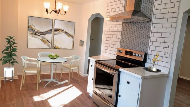 Eat in kitchen with continuous luxury vinyl plank flooring, SS appliances, and gorgeous tile back-splash. - 3155 S Fox St