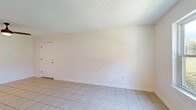 Located at 5101 Orchard Rd in Pascagoula, Mississippi, this two-story home offers three bedrooms, two bathrooms, and a well-organized layout across two floors. The main level encompasses a living room, kitchen, and utility room, while the upper level houses the bedrooms and additional bathroom. Throughout, light-toned tile flooring is prominent on the main level, complemented by light wood-look flooring in the upper-level bedrooms, creating a clean, cohesive aesthetic. Textured ceilings add a classic touch to the interior. The kitchen features white shaker-style cabinetry, light countertops, a stainless steel single-basin sink with a matte black faucet, and a stainless steel electric range — offering a functional and updated cooking space. The bedrooms are bright and simply finished, with windows bringing in natural light and views of the surrounding greenery. One bedroom includes a ceiling fan for added comfort. The bathrooms are finished with tile flooring; one includes a full tub-shower combination. The home's neutral color palette of whites and soft creams throughout provides a clean, move-in-ready canvas. A hallway and closet add to the home's practical storage and circulation.