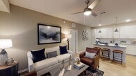 This single-story, two-bedroom, two-bathroom residence offers a well-organized layout designed for comfortable everyday living. The open-concept living area features wood-style flooring, a ceiling fan, and a glass door that invites natural light while providing access to the outdoors. The space flows seamlessly into the kitchen, which is outfitted with white cabinetry extending to the ceiling, granite-style countertops, a subway tile backsplash, stainless steel appliances, and a peninsula with bar seating illuminated by a pendant light — ideal for dining and entertaining.

A dedicated laundry closet along the hallway houses a full-size washer and dryer. The primary bedroom features plush carpeting, a window with outdoor views, and access to a private bathroom with wood-style flooring, a granite-topped vanity, and ample cabinetry. The second bedroom is equally comfortable, with carpet flooring, natural light from a large window, and a nearby closet with wire shelving. The second full bathroom mirrors the refined finishes found throughout the residence. Neutral tones and consistent, quality materials create a cohesive and polished ambiance across the entire home.