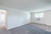 Located at 8116 Verree Rd in Philadelphia's 19111 zip code, this single-floor unit offers three bedrooms, one full bathroom, and a hallway connecting the living spaces. The layout is straightforward and functional, with neutral white walls and plush carpeting featured consistently throughout the bedrooms, contributing to a clean, understated aesthetic.

The generously sized primary bedroom is a standout feature, offering ample space for large furniture arrangements. It is equipped with two windows that invite natural light and views of surrounding greenery, a wall-mounted air conditioning unit, and baseboard heating for year-round climate control. The two additional bedrooms are well-proportioned, each outfitted with ceiling fans with integrated light fixtures, windows providing natural light, and baseboard heating units.

The full bathroom presents a clean, all-white design, featuring a tiled tub-shower combination, a window with blinds for natural light and privacy, and wood-look flooring that contrasts neatly with the soft carpeting found elsewhere in the unit.

A connecting hallway ties the rooms together efficiently. The overall ambiance is bright, neutral, and move-in ready, offering a practical and comfortable living environment.
