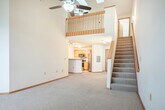 Located at 8002 Starr Grass Dr in Madison, Wisconsin, this two-story, 3-bedroom, 2-bathroom home offers a functional and comfortable layout across two floors. The main floor serves as the heart of the home, featuring a generously sized living area with plush carpeting, a ceiling fan, and an arched window that invites natural light. Track lighting adds a modern touch throughout. The kitchen is well-appointed with stainless steel appliances — including a refrigerator, range, and dishwasher — complemented by light oak cabinetry and clean white countertops, all set on tile flooring that flows seamlessly through the space. Two full bathrooms feature tile floors, oak vanities with granite-style countertops, and tub/shower combinations. Upstairs, the expansive primary bedroom impresses with soaring vaulted ceilings, skylights, a ceiling fan, and an open loft-style layout overlooking a wood-railed staircase. The additional bedrooms are carpeted and include ceiling fans and sliding-door closets. Warm wood trim and baseboards throughout the home provide a cohesive, inviting aesthetic, while the two-story design offers a clear distinction between living and sleeping areas.