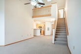 Located at 8002 Starr Grass Dr in Madison, Wisconsin, this two-story, 3-bedroom, 2-bathroom home offers a functional and comfortable layout across two floors. The main floor serves as the heart of the home, featuring a generously sized living area with plush carpeting, a ceiling fan, and an arched window that invites natural light. Track lighting adds a modern touch throughout. The kitchen is well-appointed with stainless steel appliances — including a refrigerator, range, and dishwasher — complemented by light oak cabinetry and clean white countertops, all set on tile flooring that flows seamlessly through the space. Two full bathrooms feature tile floors, oak vanities with granite-style countertops, and tub/shower combinations. Upstairs, the expansive primary bedroom impresses with soaring vaulted ceilings, skylights, a ceiling fan, and an open loft-style layout overlooking a wood-railed staircase. The additional bedrooms are carpeted and include ceiling fans and sliding-door closets. Warm wood trim and baseboards throughout the home provide a cohesive, inviting aesthetic, while the two-story design offers a clear distinction between living and sleeping areas.