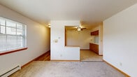 Located at 4300 S 60th St in Greenfield, WI, this single-floor, 2-bedroom, 2-bathroom unit offers a practical and well-organized layout. The living room features neutral carpet and connects openly to the dining area, which transitions into the kitchen via a half-wall pass-through — a design detail that enhances the sense of openness while maintaining distinct spaces. The kitchen is equipped with warm wood cabinetry, white appliances including a refrigerator and range, a white countertop peninsula with additional storage, and tile flooring that extends into the dining area.

Both bedrooms are carpeted and feature windows with blinds that bring in natural light and offer views of the surrounding greenery. The primary bedroom includes a wall-unit air conditioner and multiple windows, while the second bedroom offers a quieter, more compact feel. Baseboard heating is present throughout the bedrooms, ensuring consistent comfort. Three closets provide ample storage across the unit.

The two bathrooms are clean and functional. The full bath features a tiled tub-surround with an overhead shower, while the second bath includes a wood-cabinet vanity with a white countertop sink and hardwood-style flooring. Two hallways connect the spaces efficiently, completing this well-laid-out Greenfield residence.