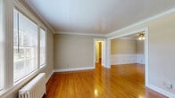 Located at 920 Woodmont Blvd in Nashville's desirable Green Hills neighborhood, this 2-bedroom, 1-bathroom unit blends classic architectural character with a warm, inviting ambiance. Rich hardwood floors flow throughout the living spaces, complemented by elegant crown molding and crisp white trim that lend a timeless quality to every room.

The living room welcomes you with large windows that flood the space with natural light, a classic cast-iron radiator, and a ceiling fan overhead. The dining room echoes this charm with decorative wainscoting panels along the lower walls, a ceiling fan, and bright window views of the surrounding greenery.

Both bedrooms are well-proportioned, with the generously sized primary bedroom offering hardwood floors, a ceiling fan, and ample natural light. The second bedroom also features hardwood flooring and a bright window.

The kitchen is functional and well-equipped, featuring warm wood cabinetry, tile flooring, a double sink, and black appliances including a gas range and refrigerator. A window above the sink provides natural light.

The bathroom retains its vintage appeal with classic black-and-white mosaic tile flooring, white subway wall tiles with black accent trim, a pedestal sink, and a soaking tub with shower — all bright and clean in presentation.