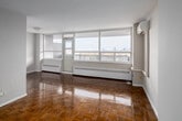 Located on the 15th floor at 155 Balliol Street in Toronto's desirable Davisville Village neighbourhood, this unit offers an open, light-filled layout with stunning panoramic views of the Toronto skyline. The living area is defined by gleaming parquet hardwood flooring and expansive floor-to-ceiling windows that frame breathtaking cityscape vistas, filling the space with abundant natural light. A wall-mounted ductless air conditioning unit ensures year-round comfort, while baseboard heating adds supplementary warmth. The bedroom is generously proportioned, featuring parquet flooring, a large window with city views, and a built-in closet providing ample storage. The kitchen is efficiently designed with white cabinetry reaching to the ceiling, dark countertops, a stainless steel refrigerator, and a dishwasher, all set on clean white tile flooring. The bathroom features a dark granite-topped vanity with white cabinetry, a large wall mirror, and tile flooring. Throughout the unit, neutral white walls and a clean, minimalist palette create a bright and versatile living environment well-suited to a variety of interior styles.
