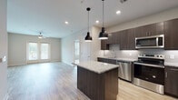 This well-appointed 2-bedroom, 2-bathroom unit at 2190 Northlake Pkwy in Tucker, GA offers a thoughtfully designed single-floor layout that balances modern style with everyday functionality. The open-concept living and kitchen area serves as the heart of the home, anchored by a central island with granite countertops and pendant lighting overhead. Dark espresso cabinetry contrasts beautifully with the light wood-style flooring, while a classic tile backsplash adds texture to the kitchen walls. Stainless steel appliances — including a refrigerator with ice maker, electric range, microwave, and dishwasher — complete the chef-ready space. The living area extends naturally from the kitchen, with a ceiling fan and access to natural light through large windows and a private entry door. Both bedrooms feature plush carpeting, ceiling fans, and generously sized windows that invite abundant natural light. The primary suite includes an en-suite bathroom with a dual-sink granite vanity, dark cabinetry, and a soaking tub. The second bathroom mirrors the same refined finishes, featuring a granite vanity, dark cabinetry, and a large mirror. Built-in shelving and walk-in closets provide ample storage throughout the unit.