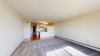 Located at 2550 Second St in Cuyahoga Falls, OH, this one-bedroom, one-bathroom unit offers a well-organized single-floor layout with a comfortable living space. The combined living room and kitchen area forms the heart of the home, where plush carpeting transitions to hardwood-style flooring. The living room is bright and airy, featuring exposed brick accent walls, a ceiling fan with light fixture, a baseboard heating system, and a large sliding glass door that opens to a private balcony with scenic outdoor views. The galley-style kitchen is efficiently designed with ample upper and lower cabinetry, granite-look countertops, a white tile backsplash, a stainless steel sink, and stainless steel appliances including a range, microwave, and refrigerator, all illuminated by overhead lighting and a chandelier. The spacious bedroom is carpeted and includes a ceiling fan, as well as multiple closet spaces with louvered bifold doors, providing abundant storage. The bathroom features warm hardwood-style flooring, a white tiled tub-shower combination with grab bars, a toilet, and a vanity with a sink and mirror. With four closets throughout, the unit offers exceptional storage for its size.
