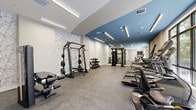 This fitness room at 1559 NW 15th Street Rd in Miami, FL offers a thoughtfully designed exercise space that combines modern aesthetics with comprehensive workout functionality. The room features a striking two-tone ceiling design, with a bold steel-blue accent contrasting against crisp white sections, illuminated by sleek linear LED lighting that ensures bright, even coverage throughout. A decorative marble-patterned feature wall adds a refined touch to the otherwise clean, white interior. Large windows along one side of the room invite abundant natural light and provide views of the surrounding greenery, creating an energizing atmosphere. The durable speckled rubber flooring provides both safety and comfort underfoot. Equipment is well-organized and spans both cardio and strength training categories. The cardio section includes multiple treadmills, an elliptical trainer, and a rowing machine, all positioned to take advantage of the natural light and outdoor views. The strength training area is anchored by a multi-functional cable machine and a power rack with weight plates, complemented by a tiered dumbbell rack offering a range of free weights. Full-length mirrors on one wall enhance the sense of space and allow users to monitor their form. The room is well-ventilated with visible ceiling vents, and the open layout ensures comfortable circulation throughout the space.