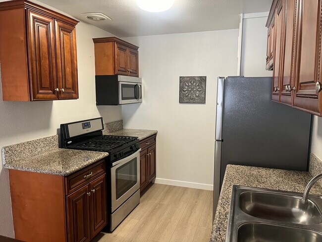 La cocina cuenta con estufa/hornilla de acero inoxidable, microondas y refrigerador. - 375 Vernon Drive