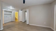 This efficiently designed 1-bedroom, 1-bathroom unit is laid out across a single floor, offering a practical and comfortable living experience. Light wood-style flooring flows consistently throughout, complementing the neutral, warm-toned walls and white trim found in every room.

The living room serves as the heart of the space, highlighted by a corner fireplace with a dark surround and a ceiling fan overhead. A large sliding glass door fitted with vertical blinds fills the room with natural light and provides outdoor access. An open pass-through connects the living area to the kitchen, enhancing the sense of openness.

The kitchen is well-equipped with white cabinetry, light countertops, a classic subway tile backsplash, and stainless steel appliances including a refrigerator and an electric range. The layout makes efficient use of the available space.

The bedroom is a comfortable, well-lit room featuring a ceiling fan, a large window dressed with horizontal blinds that allow ample natural light, and a dedicated closet for storage.

The bathroom is cleanly finished with a modern floating wood-toned vanity, a white countertop, a tiled tub-shower combination with grab bar, and wood-look tile flooring. Textured ceilings are a consistent architectural detail present throughout the unit.
