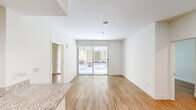 This single-story, 3-bedroom, 2-bathroom home offers a thoughtfully designed floor plan that maximizes every square foot. Light wood flooring runs consistently throughout, creating a warm and cohesive aesthetic across all rooms.

The open-concept kitchen and living area serves as the heart of the home. The kitchen is outfitted with warm wood cabinetry, granite countertops, stainless steel appliances including a gas range, microwave, refrigerator, and dishwasher, along with a peninsula that provides added prep space and a natural division from the living area. The bright living room features large sliding glass doors that open to a private outdoor patio, filling the space with natural light and providing a seamless indoor-outdoor connection.

The three bedrooms are clean and well-proportioned, each with white walls and wood flooring. The primary bedroom is generously sized and features double doors leading to a closet. Additional bedrooms offer windows with views to the exterior, with one featuring its own sliding glass door access. Two dedicated closets provide practical storage throughout.

Both bathrooms are finished in clean white tiling and include full tub-shower combinations with brushed nickel fixtures. The overall ambiance is bright, neutral, and move-in ready.