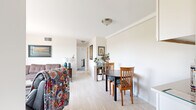Located at 2915 W 50th St in Minneapolis, this 2-bedroom, 1-bathroom unit offers a practical and well-organized layout across a single floor. The living room serves as the heart of the unit, featuring large windows that frame lush treetop views and flood the space with natural light. Light wood-style flooring runs through the main living and dining areas, creating a clean, cohesive look, while baseboard heating is present throughout. A dedicated dining area sits adjacent to the living room, offering a comfortable space for everyday meals. The kitchen features white cabinetry, light countertops, a stainless steel sink, and a window that brings in additional natural light. The primary bedroom is a well-proportioned retreat with two windows overlooking the treetops, carpeted flooring, a ceiling fan, and ample space for furnishings. The second bedroom also features carpeted flooring, a bright window with outdoor views, and a closet with louvered doors. The full bathroom is finished with classic mosaic tile flooring, white tilework, a vanity with mirror, and a shower/tub combination. Throughout the unit, neutral tones and abundant natural light create a bright, calm atmosphere well-suited for Minneapolis urban living.