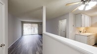 This single-floor residence offers a clean, functional layout with a neutral color palette throughout. The living room is a standout space, featuring contemporary grey wood-look flooring, large sliding glass doors that invite abundant natural light and provide outdoor views, and a wall-mounted air conditioning unit complemented by baseboard heating. The open layout flows seamlessly from the living area into an adjacent space separated by a half-wall divider, adding architectural interest while maintaining a connected feel. The textured ceilings add a classic touch consistent throughout the unit.

The bedroom is generously sized, finished with soft wall-to-wall carpeting and a window dressed with vertical blinds that allows natural light in. A standout feature of the bedroom is the dual closet configuration — two side-by-side bi-fold closets with wooden dowel rods and shelving, offering exceptional storage capacity.

The bathroom is finished with white tile flooring and wall tile surround, featuring a shower and tub combination. The overall design of the space is practical and move-in ready, with a consistent use of light grey and white tones that create a bright, cohesive atmosphere throughout each room. Baseboard heating is present in multiple rooms, ensuring efficient climate control year-round.
