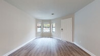 Located at 415 W 10th Street in Charlotte, NC's vibrant West End neighborhood, this single-floor unit offers a thoughtfully updated interior with a clean, neutral color palette throughout. Light-toned luxury vinyl plank flooring runs continuously across the living spaces, complemented by crisp white trim and textured ceilings that add subtle dimension.

The open living area is defined by a distinctive bay window arrangement that floods the space with natural light and provides views of the surrounding neighborhood. A pass-through kitchen connects seamlessly to the main living and hallway areas, featuring white shaker-style cabinetry, granite countertops, a stainless steel sink, and a full suite of stainless steel appliances including a refrigerator and dishwasher. Louvered bifold doors provide convenient access to additional storage or utility areas adjacent to the kitchen.

The bedroom is generously proportioned, featuring its own bay window configuration for ample natural light, along with built-in louvered closet doors offering practical storage. A secondary room with a glass-paneled exterior door provides flexible use as an additional bedroom or private retreat with direct outdoor access.

The bathroom presents a clean, updated design with a shaker-style vanity, framed mirror, and combination tub and shower. Throughout the unit, the understated finishes and well-maintained condition make it a functional and comfortable space in the heart of Charlotte.
