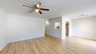 Located at 75 Nightingale Dr in Gulf Breeze, FL, this single-floor, 2-bedroom, 2-bathroom home offers a clean, modern aesthetic throughout. Light wood laminate flooring runs continuously across the living spaces, creating a cohesive and bright atmosphere. The combined dining and living area is open and well-proportioned, featuring a ceiling fan with light fixture and a pass-through window that connects seamlessly to the kitchen, enhancing the sense of openness. The kitchen is efficiently designed in a U-shape layout, outfitted with white cabinetry, dark granite countertops, stainless steel appliances including a refrigerator and range, and a stainless steel sink — offering a sleek, functional workspace. Both bedrooms are comfortably sized, each with ceiling fans, neutral gray walls, and natural light from windows with blinds. The primary bedroom is generously proportioned and includes closet access. The two bathrooms differ in style: one features a tub-shower combination with chrome fixtures and classic white tile, while the other offers a vanity with dark granite countertops, white cabinetry, and matching wood flooring. A hallway, closet, and patio round out the layout, completing this well-organized and move-in-ready home.