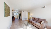 Located at 618 E Leicester Ave in Norfolk, VA, this single-floor, 2-bedroom, 1-bathroom residence offers a practical and comfortable layout. The open living room is bright and welcoming, featuring light wood-style flooring, neutral white walls, and windows that bring in generous natural light. A ceiling fan adds to the room's functionality, and the space flows seamlessly toward the kitchen area.

The kitchen is well-appointed with light wood cabinetry, ample counter space with neutral laminate surfaces, a double-basin sink, a dishwasher, and a white electric range. A window above the counter allows natural light to fill the space, creating an airy cooking environment.

The primary bedroom is a spacious retreat with soft carpeting, neutral walls, and natural light from a side window. It features two closets, providing generous storage. The second bedroom is equally cozy, also carpeted, with a bright window and its own closet with built-in shelving.

The bathroom is clean and functional, offering a full tub-shower combination with tiled surround, a wooden vanity, and wood-style flooring. A connecting hallway ties the layout together efficiently. Throughout, the residence maintains a consistent, understated aesthetic with light tones and practical finishes suited for comfortable everyday living.