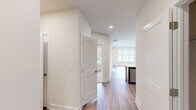 Located at 1371 US-206 in Skillman, NJ, this well-appointed one-bedroom, one-bathroom residence offers a thoughtfully designed single-floor layout. The open-concept kitchen and living area serves as the heart of the home, showcasing dark shaker-style cabinetry, a granite-topped peninsula with an undermount sink, white subway tile backsplash, and a full suite of stainless steel appliances including a gas range, microwave, and French door refrigerator. Hardwood-style flooring runs throughout the main living areas, complemented by recessed lighting and an abundance of natural light from large windows dressed with neutral roller shades. The spacious living room benefits from a wide triple-panel window overlooking the surrounding greenery. The bedroom features plush carpeting, a generous walk-in closet with built-in shelving, and a window with outdoor views. The full bathroom is finished with neutral tile flooring, a tub-shower combination accented by a mosaic tile border, a curved shower rod, and a dark-cabinetry vanity with a white countertop. A dedicated laundry room and a connecting hallway complete this clean, modern, move-in-ready residence.