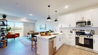 This thoughtfully designed one-bedroom, one-bathroom residence in New Prague, MN offers a well-organized single-level layout that maximizes comfort and functionality. The open-concept kitchen and living area serves as the heart of the home, featuring crisp white shaker cabinetry, a subway tile backsplash, stainless steel appliances, and a central island with pendant lighting — ideal for both cooking and casual dining. Light wood-tone flooring flows throughout the main living areas, lending a warm, cohesive feel.

The living room is bright and welcoming, with a sliding glass door that opens onto a private balcony offering pleasant outdoor views of the surrounding landscape. The bedroom is a serene retreat, carpeted for comfort and filled with natural light from a large window overlooking the greenery outside. A ceiling fan adds practicality, and the room connects conveniently to two closets, including a walk-in with built-in shelving.

The bathroom is clean and modern, outfitted with a white vanity featuring black hardware, a full tub-shower combination, and wood-look flooring. Additional highlights include an in-unit laundry area and a utility room, rounding out a complete and efficient living space.